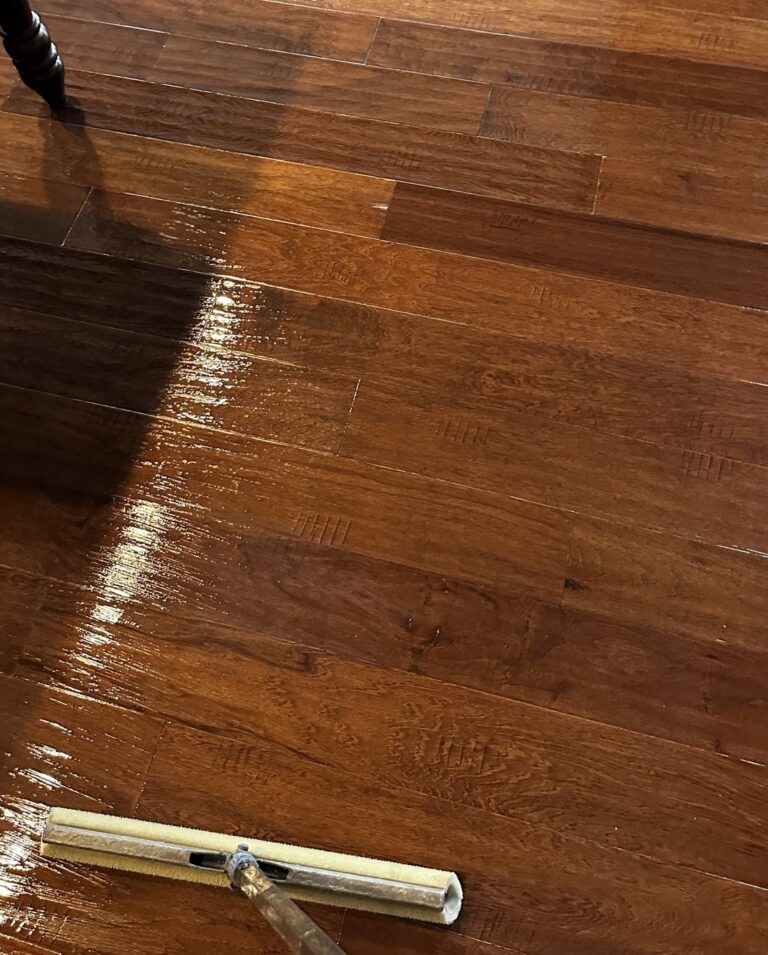 Applying a fresh coat of finish on a hardwood floor