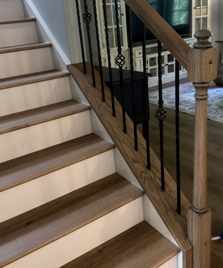 Staircase with oak handrail, twisted iron balusters and LVP treads with white risers